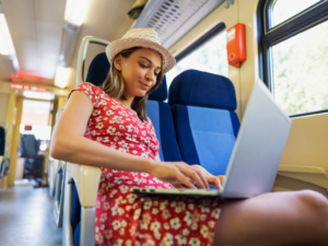 Young woman working on her laptop while riding on the train